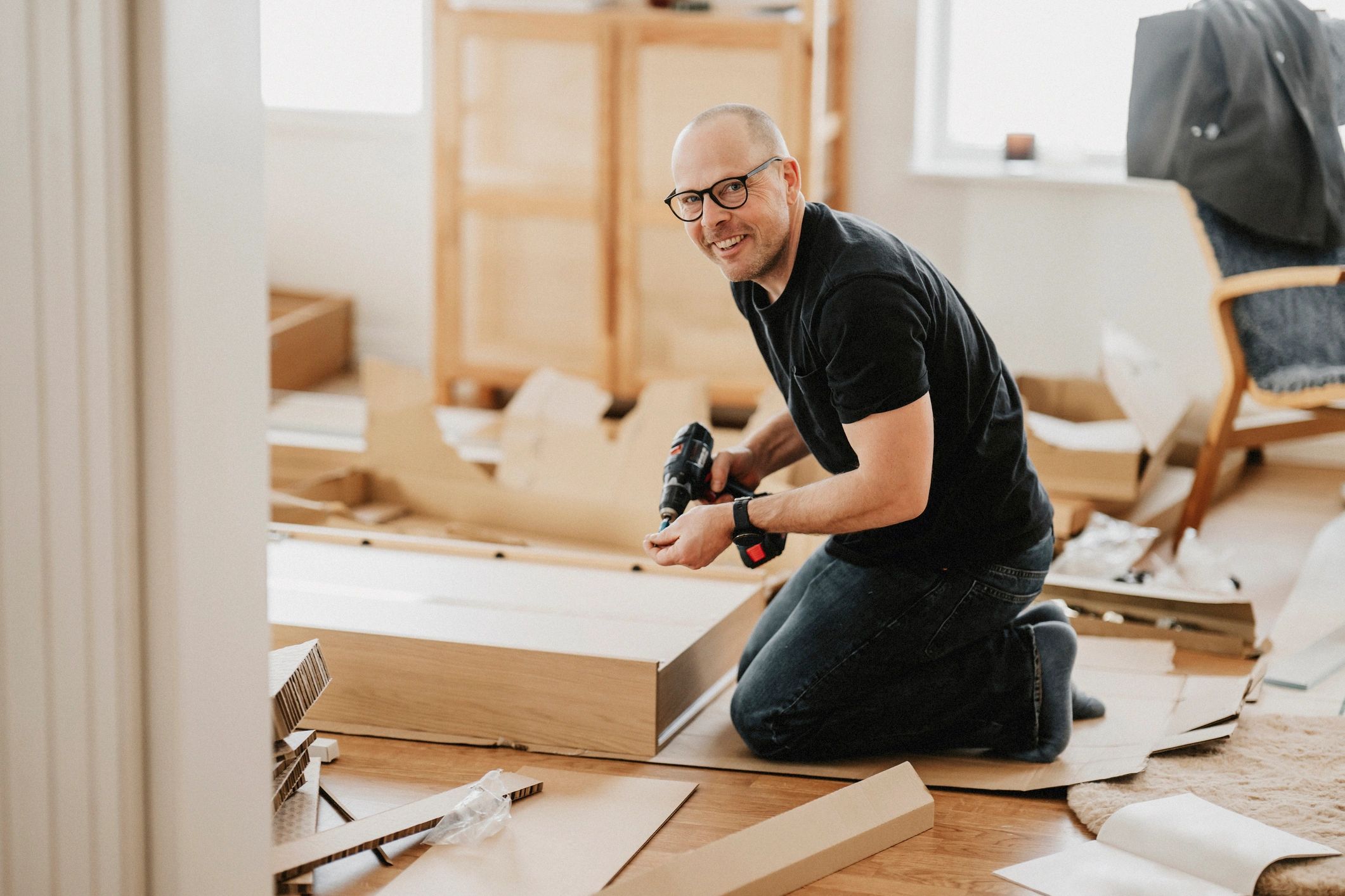 Handyman assembling furniture in a living room
